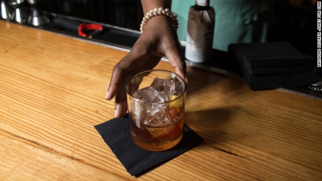 Tiffanie Barriere serves a drink behind the bar at One Flew South on Concourse E.