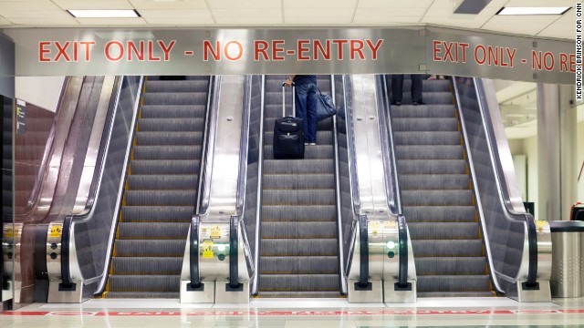 Passengers take the escalator to ground transportation and baggage claim.