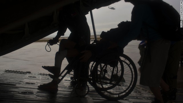 A sick elderly man is wheeled onto a Philippines military cargo aircraft as he and fellow survivors of the typhoon are evacuated from Tacloban to Manila on November 23.