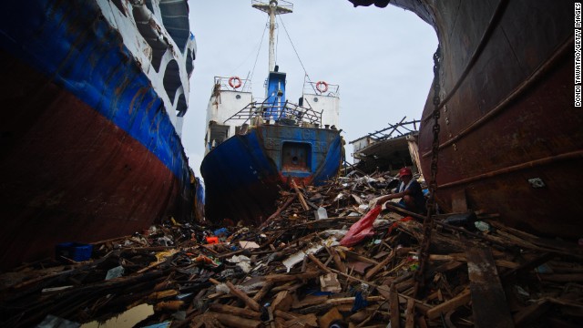 A man scavenges piles of wood amid damaged container vessels on November 23 in Tacloban. 