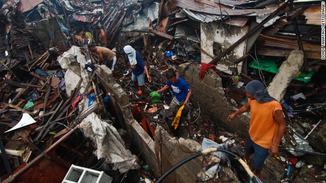 Groups of men clear debris near the shoreline on November 23 in Tacloban.