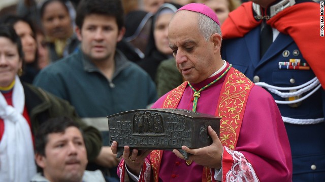 Italian archbishop Rino Fisichella holds the ashes of St Peter before a ceremony of Solemnity of Our Lord Jesus Christ the King at St Peter's square on November 24, 2013 at the Vatican.