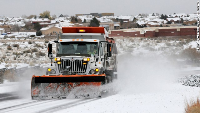 A plow and sanding truck heads up Paseo del Norte in Albuquerque, New Mexico, on Sunday, November 24. A deadly winter storm that began in Southern California and stretches to Texas threatens to wreck Thanksgiving week travel plans all the way to the Atlantic.