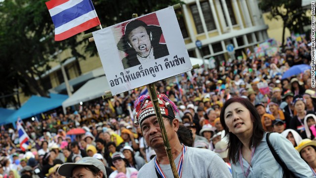A Thai opposition protester holds up a placard mocking exiled former leader, Thaksin Shinawatra. Thaksin has a strong support base among Thailand's rural and working class, but is detested among the elite and middle classes, who accuse him of corruption.