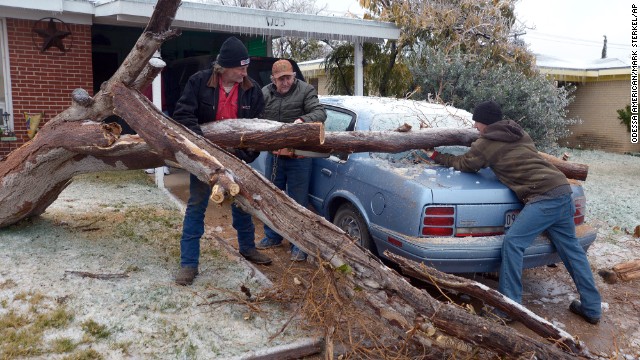 A fallen tree is removed from a car in Odessa, Texas, on Monday, November 25. The deadly winter storm that began in Southern California and stretches to Texas threatens to wreck Thanksgiving week travel plans all the way to the Atlantic.