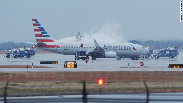 Employees at Dallas-Fort Worth International Airport de-ice a plane before departure on Monday, November 25.