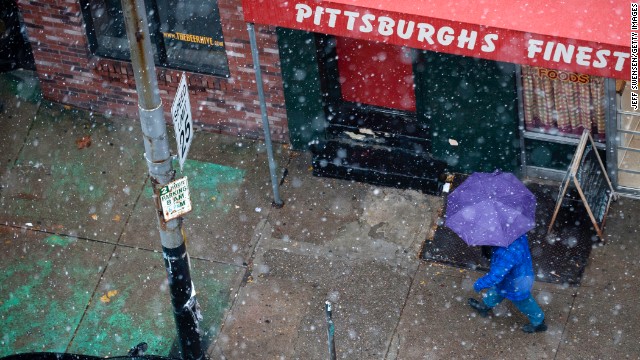 A pedestrian walks through snow showers along Penn Ave in Pittsburgh on November 26.