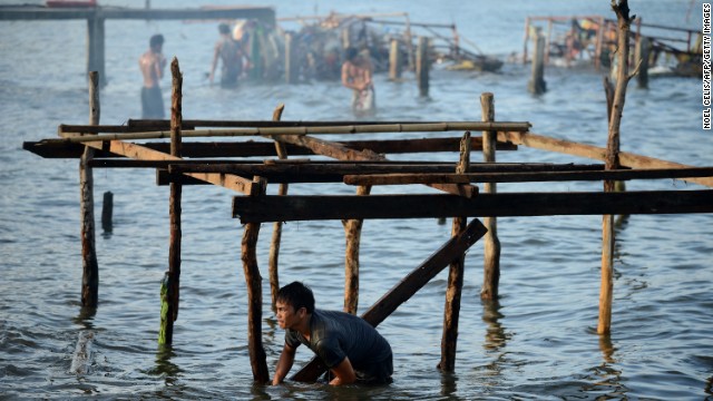 A man reconstructs his house in the bay of Tacloban, Leyte province, Philippines, on Wednesday, November 27, 2013. Typhoon Haiyan, one of the most powerful storms on record, hit the country's eastern seaboard on November 8, leaving a wide swath of destruction, including more than 5,000 deaths.