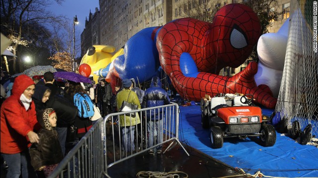 Sightseers photograph the balloons, including Spiderman and Pikachu, on the night before the parade. 