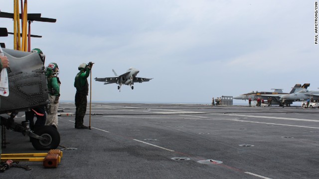 The carrier's air wing carry out launch and recovery operations night and day -- an FA-18 on final approach ...