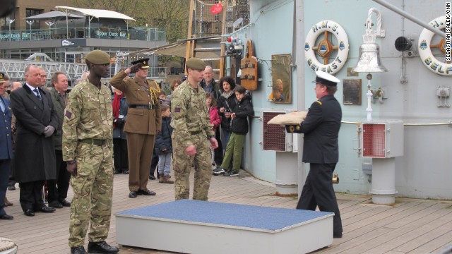 One of the bags of soil is handed over on board HMS Belfast in London