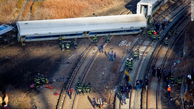 Firefighters and emergency rescuers swarm the scene near Spuyten Duyvil station in the Bronx, where train cars had flipped on their sides. One car was just feet away from the Harlem River.