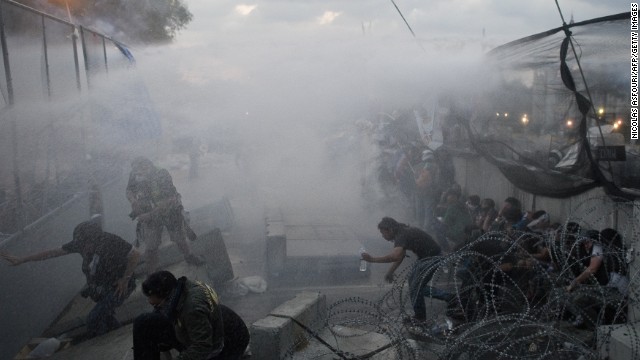 Anti-government protesters run for cover December 1 as police use tear gas and water cannons.