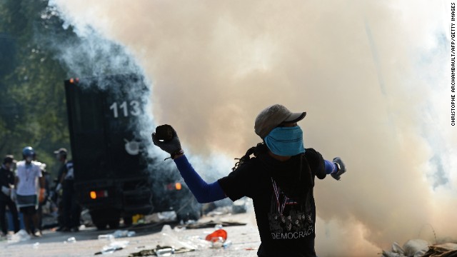 A protester throws a stone at police Monday, December 2, during a rally outside government headquarters in Bangkok, Thailand.