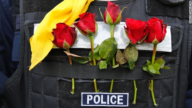 A police officer wears flowers offered by protesters in his bulletproof vest in Bangkok on December 3.