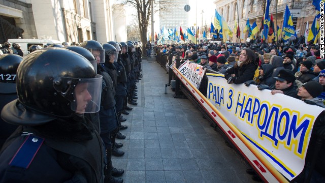 Police stand guard opposite a sea of protesters near the Ukrainian parliament in Kiev on Tuesday, December 3. Riot police lined up to protect the office of President Viktor Yanukovich, whose decision not to sign a landmark trade deal with the European Union sparked the public outrage. 