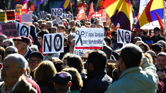 Demonstrators hold placards and flags of the Second Spanish Republic as they take part in a protest against the government's austerity measures in Madrid on November 23, 2013. 