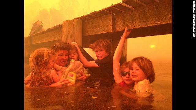 <strong>January 4:</strong> Tammy Holmes and her grandchildren take refuge under a jetty as a wildfire rages nearby in the Tasmanian town of Dunalley, Australia.