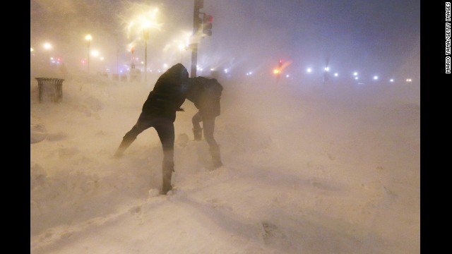 <strong>February 8:</strong> People shield themselves from snow as a blizzard arrives in the Back Bay neighborhood of Boston.