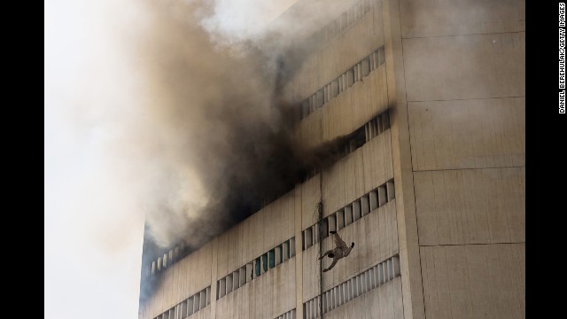 <strong>May 9:</strong> A man overcome by fumes falls out of a window as a fire burns at the Lahore Development Authority Plaza in Lahore, Pakistan.