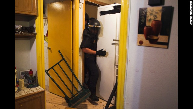 <strong>September 25:</strong> Police push away a refrigerator as they enter the Madrid apartment of Maria Isabel Rodriguez Romero. Romero and her family of six were evicted by the State City Hall Housing Company. Spain is slowly emerging from a two-year recession, but it still has a high unemployment rate and evictions have rapidly increased as borrowers are unable to pay their mortgages.