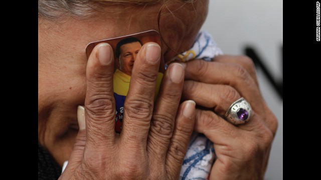 <strong>March 6:</strong> A crying woman holds a picture of Venezuelan President Hugo Chavez outside the military hospital where he died one day earlier in Caracas, Venezuela. Chavez, who had battled cancer, was 58.