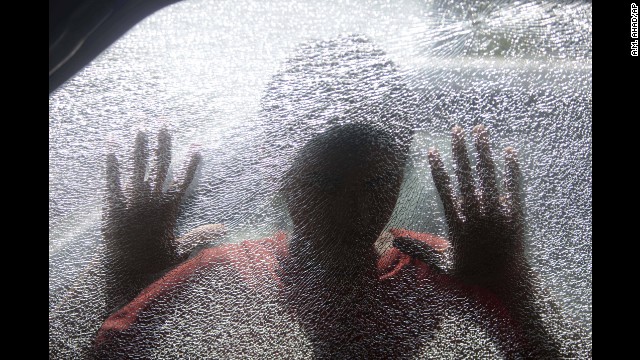 <strong>March 18:</strong> A Bangladeshi boy looks inside a car vandalized by activists of the Bangladesh Nationalist Party during a general strike in Dhaka, Bangladesh.