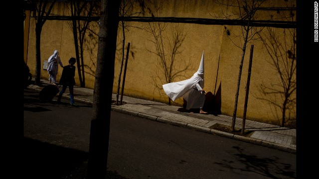 <strong>March 24:</strong> Hooded penitents from the La Paz brotherhood walk to a church in Seville, Spain, to take part in a procession during Easter Holy Week.