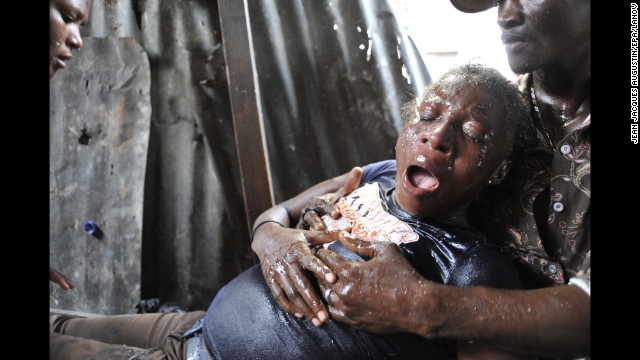 <strong>September 30:</strong> A woman in Port-au-Prince, Haiti, suffers an asthma attack after tear gas was used during an anti-government demonstration on the anniversary of the 1991 coup against former President Jean-Bertrand Aristide.