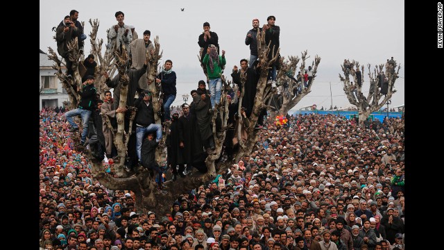 <strong>February 1:</strong> Kashmiri Muslims stand on a tree as they offer prayers at the Hazratbal Shrine in Srinagar, India.