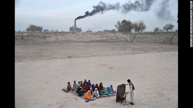 <strong>December 1:</strong> Schoolchildren take lessons at a refugee camp on the outskirts of Jalalabad, Afghanistan.