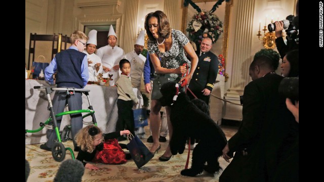 <strong>December 4:</strong> First lady Michelle Obama reacts as 2-year-old Ashtyn Gardner loses her balance after greeting Sunny, one of the Obamas' dogs, during a holiday arts-and-crafts event at the White House.