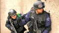 A swat team assess risk before raiding a building