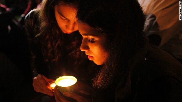 People light a candle for Mandela outside his home in Johannesburg on December 5.