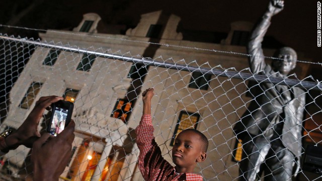Keaton Anderson, 10, poses for a photograph while he and his father visit Mandela's statue at the South African Embassy in Washington on December 5. The statue is under renovation.