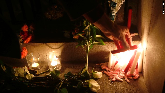 A man lights a candle for Nelson Mandela outside the South African High Commission in London, on December 6.