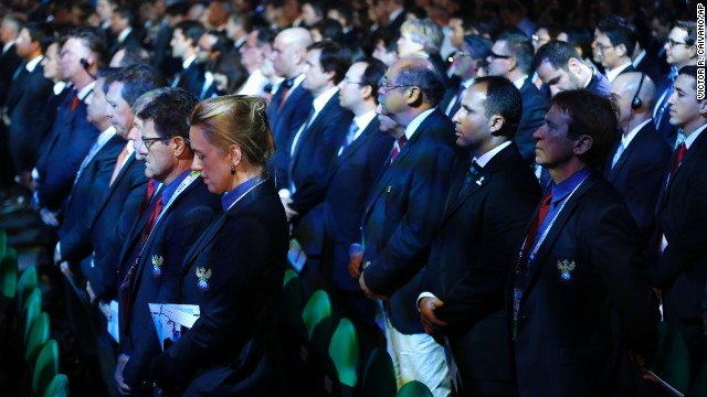 Delegates from countries all over the world stand for a moment of silence for Mandela on December 6 during the drawing ceremony for the 2014 World Cup in Costa do Sauipe, Brazil.