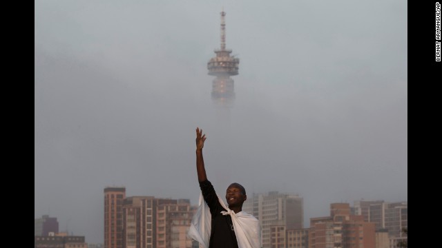 A mourner prays on a hill overlooking Johannesburg on Sunday, December 8.
