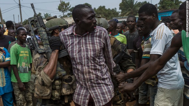 People gather around an alleged ex-Seleka rebel as he is arrested by French soldiers in Bangui on December 9. French soldiers began disarming fighters after a swell of violence. Christian vigilante groups have formed to battle Seleka, the predominantly Muslim coalition behind the president's removal.