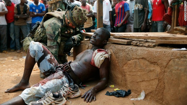 A French soldier speaks to a suspected Christian militia member who was wounded by a machete in the Kokoro neighborhood of Bangui on December 9. Vigilante crowds said they spotted him with grenades and turned him in to French forces. Both Christian and Muslim mobs went on lynching sprees as French forces deployed in the capital.