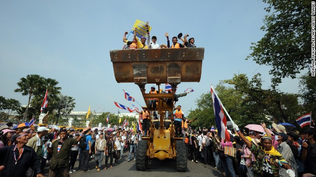 Anti-government protesters celebrate after removing concrete barricades outside the Government House in Bangkok on December 9.