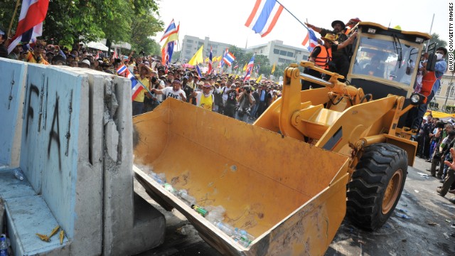 Protesters use a bulldozzer to clear a police barricade blocking an access road leading to Government House during a large anti-government rally on December 9.