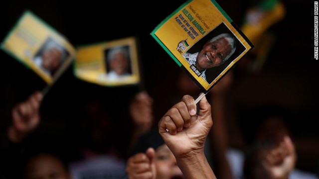Mourners wave flags at a telecast of the memorial service at Ellis Park in Johannesburg.