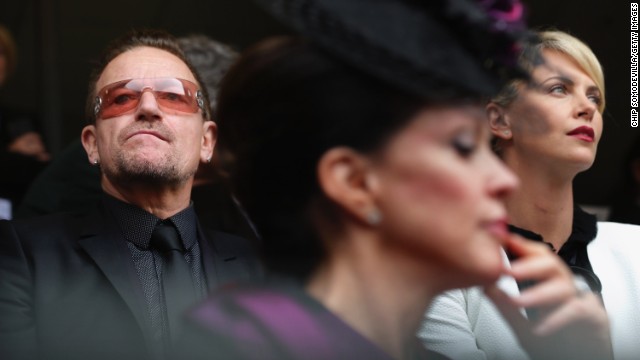 Singer Bono and actress Charlize Theron attend the memorial service.