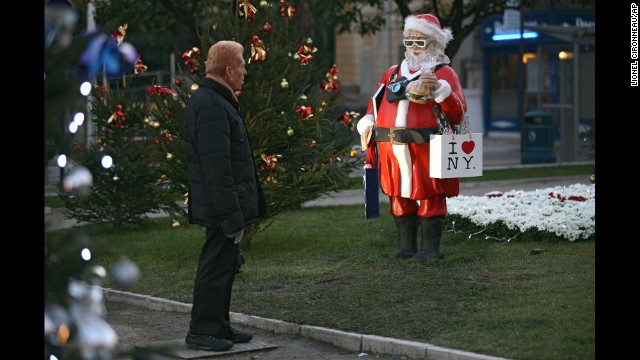 A man checks out a statue called "Santa Claus Tourist in the USA" in Menton, France, on December 9.