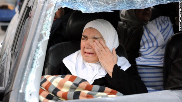 A woman weeps inside a damaged vehicle after forces loyal to President Bashar al-Assad captured the town of Nabak on Monday, December 9.