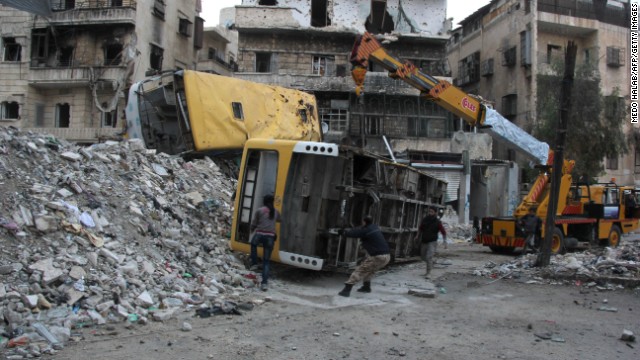 Rebel fighters in Aleppo fortify a barricade with destroyed public buses on Wednesday, December 4.