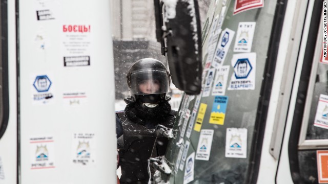 A young police officer guards a roadblock on Institutskaya Street near the presidential area in Kiev on December 11. Riot police tried to break into City Hall, which is held by protesters, but they were forced to retreat.