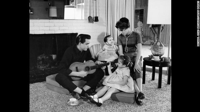 Cash holds a guitar as his then-wife Vivian Liberto and daughters Rosanne and Kathy look on in 1957. 