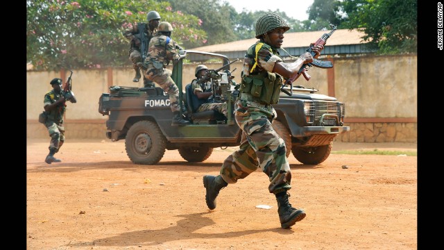 Troops from the Multinational Force of Central Africa, regional peacekeepers, shoot as they attempt to evacuate Muslim clerics from the St. Jacques Church in Bangui on Thursday, December 12. An angry crowd had gathered outside the church following rumors that a Seleka general was inside.